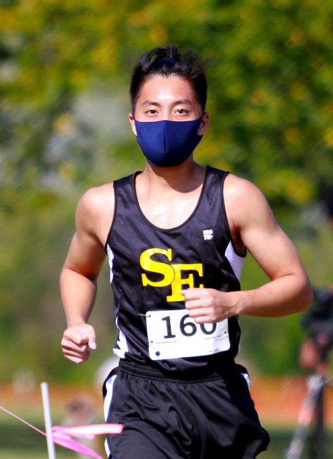 Sr. Minh-Tri Bui wears a mask as he runs in a cross country meet at Cessna Activity Center.