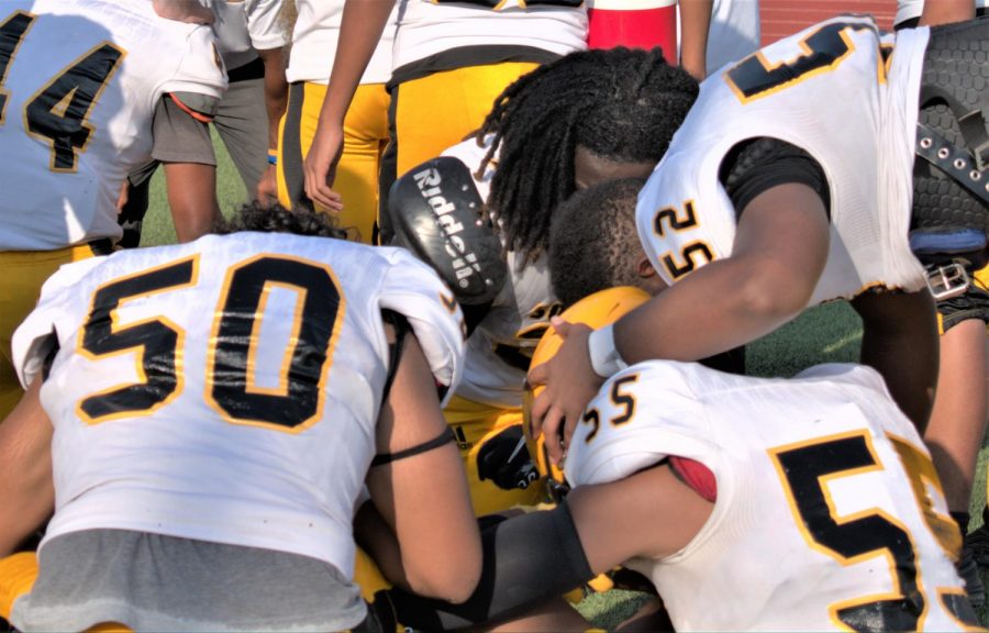Football players console each other following their final practice after fall sports were cancelled by the district.