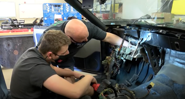 Andrews and student working on the car.