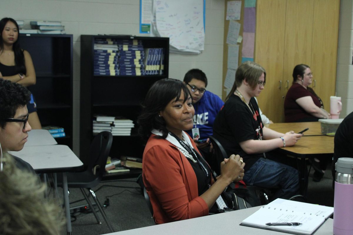 Dr. Redic attends town hall meetings and actively listens and takes notes about students' concerns.